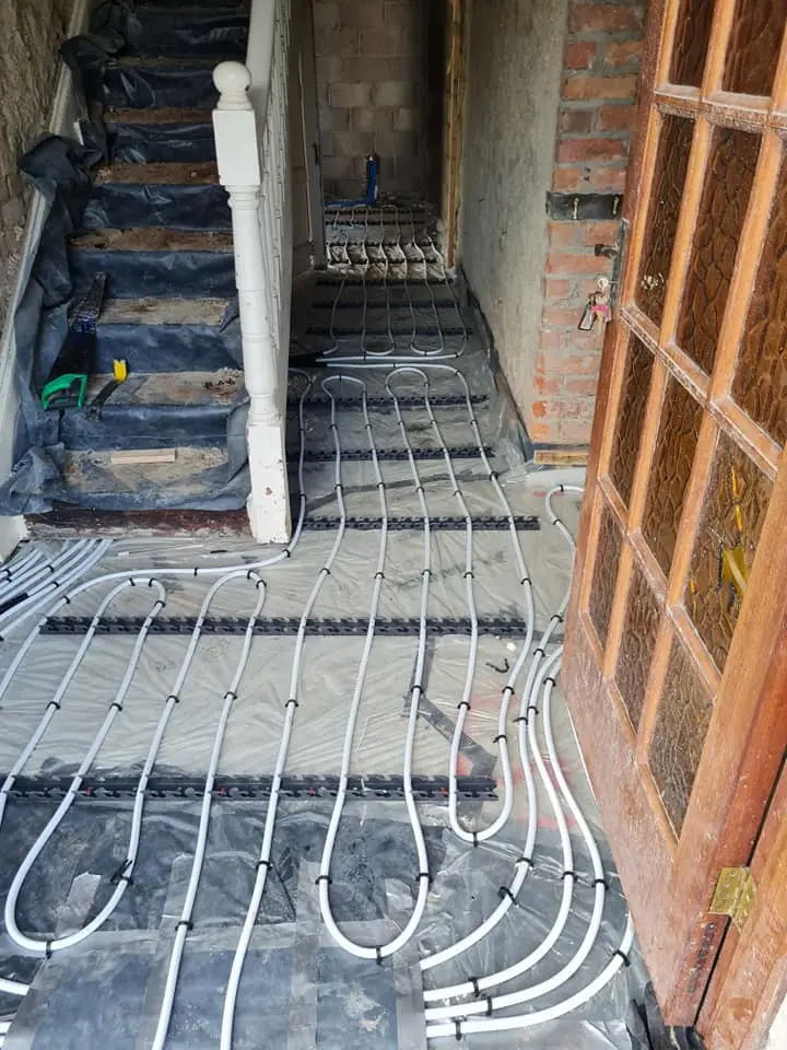 Underfloor heating installation in a hallway with staircase in a Cavan home