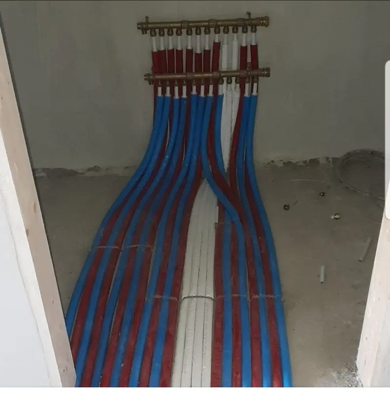 Heating manifold with blue and red insulated pipes connected to copper header